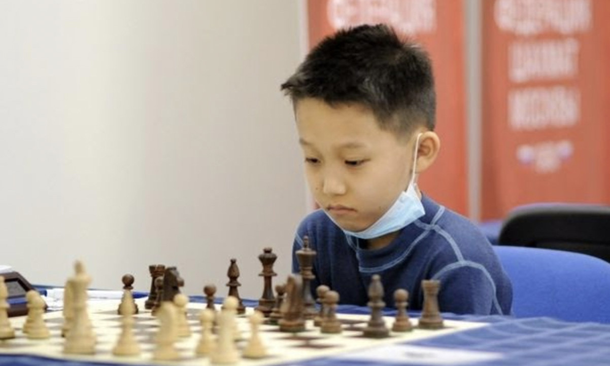 roman shogdzhiev with a chess board