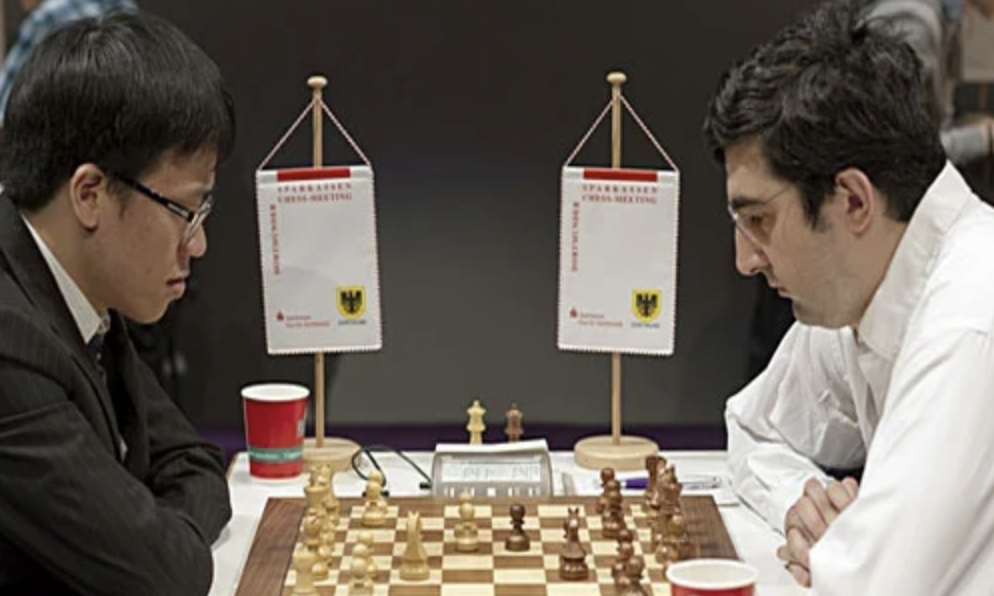Vladimir Kramnik vs Le Quang Liem sitting beside a chess board in Dortmund in 2011.